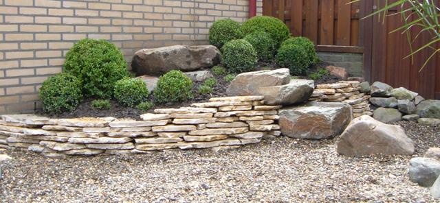 Rotstuin met siergrind, keien en gesnoeide buxus