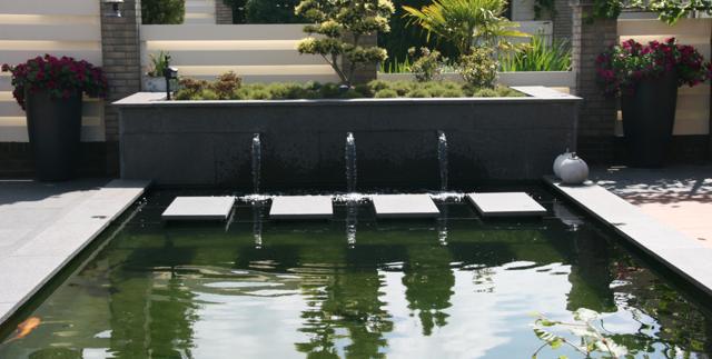 Verhoogde design vijver met waterval en avondverlichting